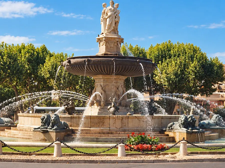 The Rotonde fountain, its statues and jets of water, in front of the plane trees of Aix-en-Provence