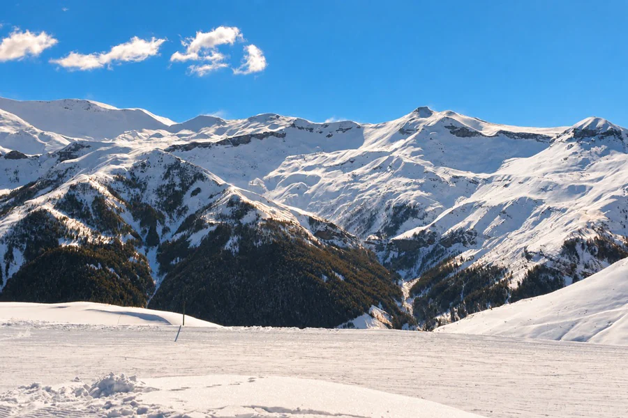 A groomed run at Auron facing snow-capped peaks