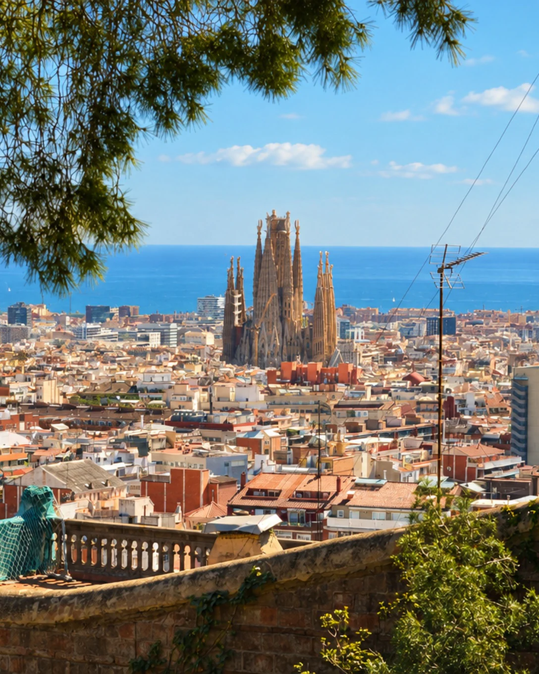 La Sagrada Família au-dessus des toits de Barcelone, vue du parc Güell, la mer à l’horizon