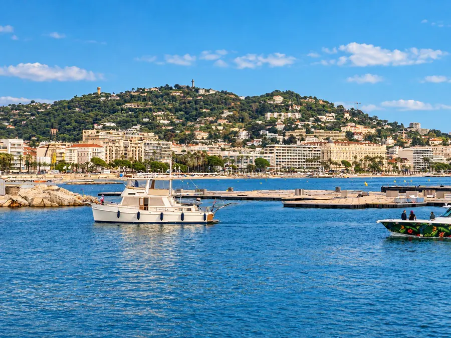 Bateaux sur la baie de Cannes, devant le front de mer et la colline couverte de maisons