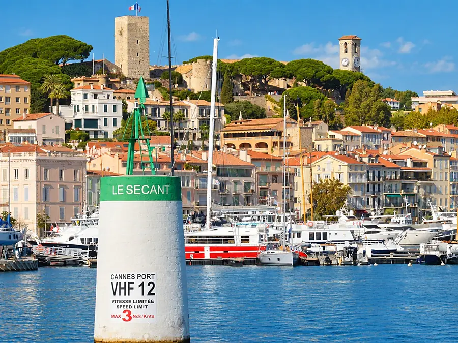 Yachts and sailing boats moored in the Vieux Port of Cannes, below the old town of Le Suquet
