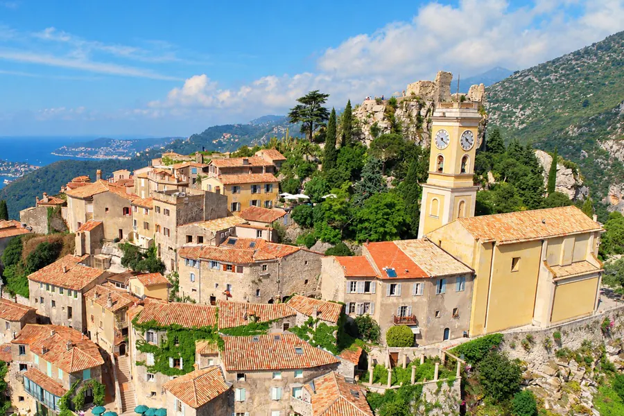 The rooftops of Èze, its bell tower and the bay, with yachts at anchor
