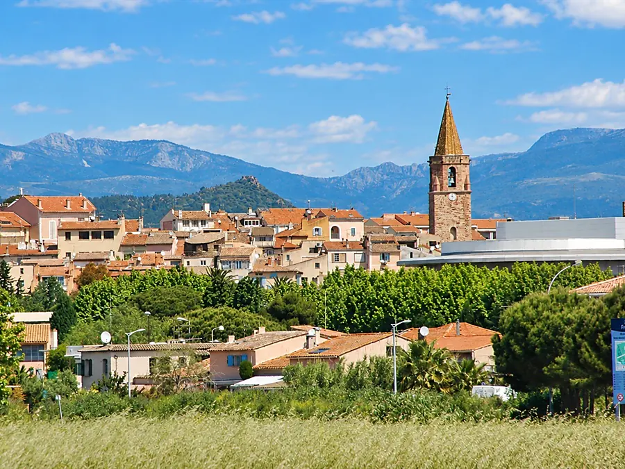Fréjus and its cathedral bell tower above the rooftops, mountains beyond