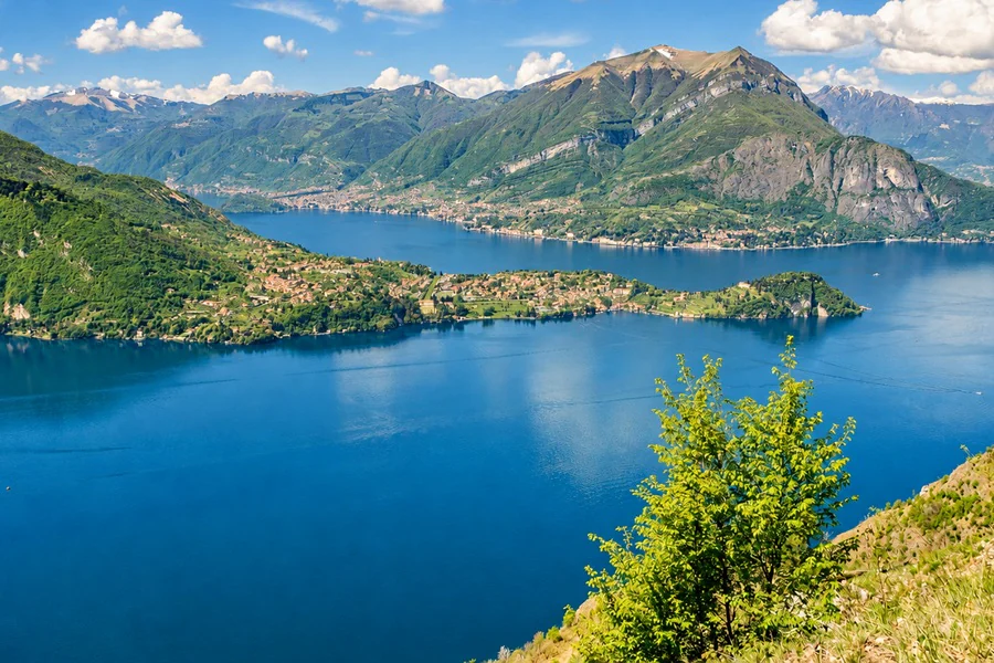 Lake Como seen from above, its mountains and a small peninsula lined with villages