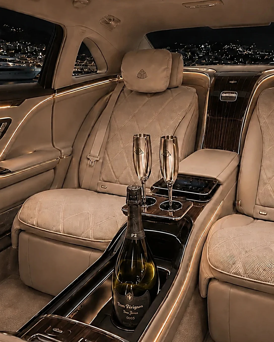 Rear cabin of a Mercedes-Maybach with two champagne flutes and a chilled bottle, ready for a private chauffeur service for your transfer to Auron