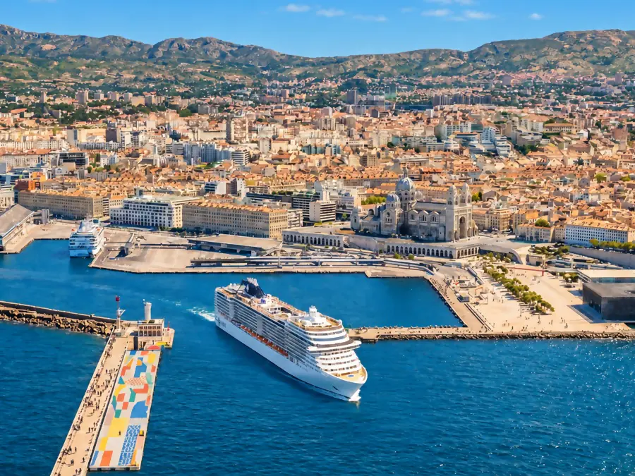 A cruise ship leaving the port of Marseille, in front of La Major cathedral and the MuCEM