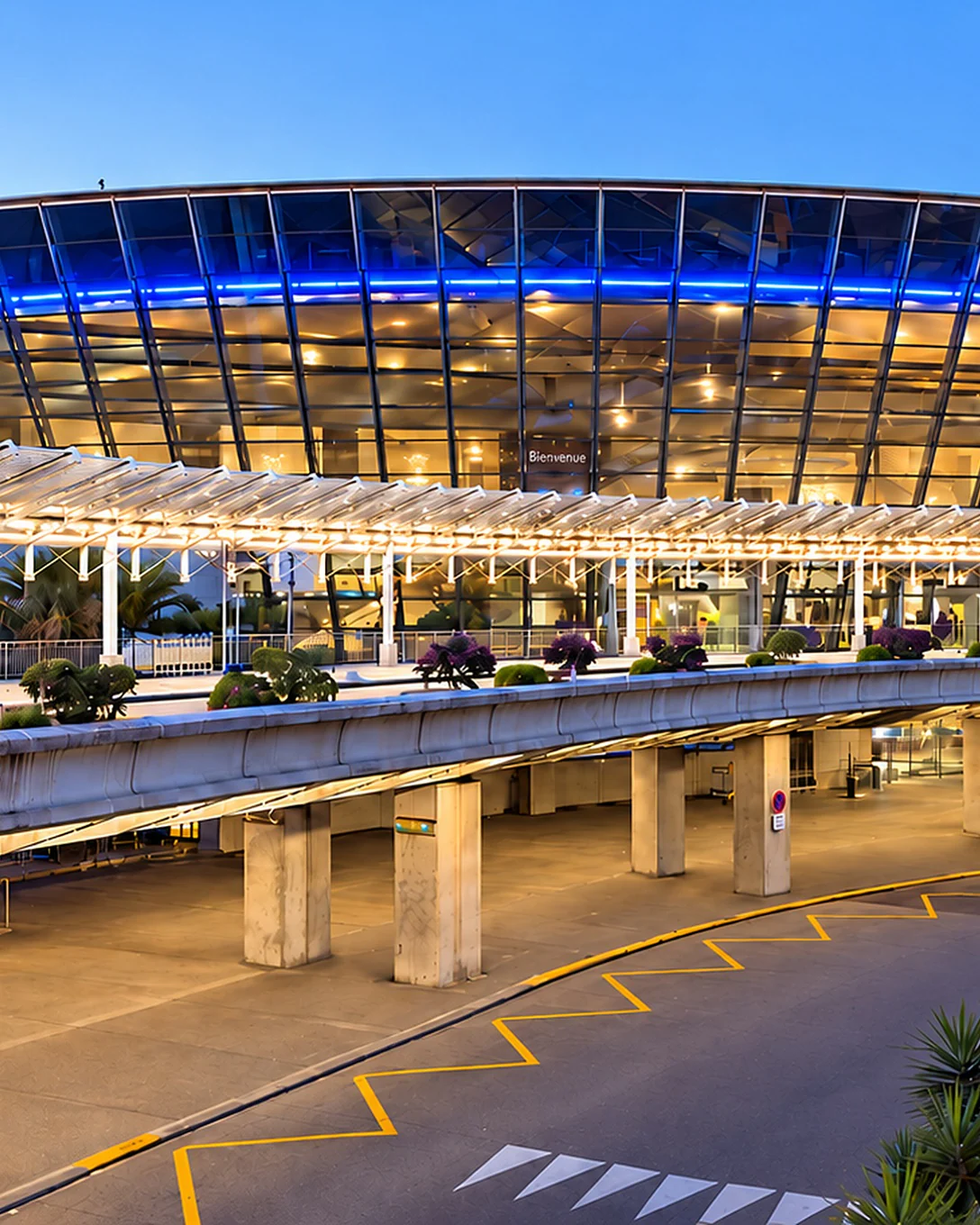 Terminal vitré de l’aéroport de Nice Côte d’Azur, entouré de palmiers