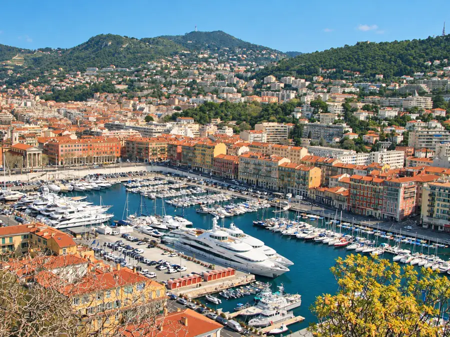 The port of Nice seen from the heights, its yachts and the ochre facades around the harbor, below the hills
