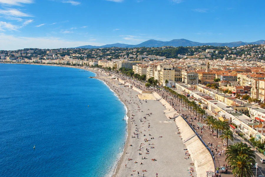 The Promenade des Anglais and the pebble beach along the Baie des Anges in Nice