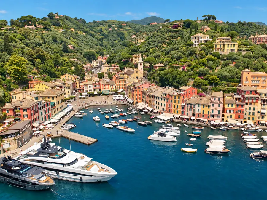 The small harbor of Portofino, its colorful facades and yachts, below the wooded hills