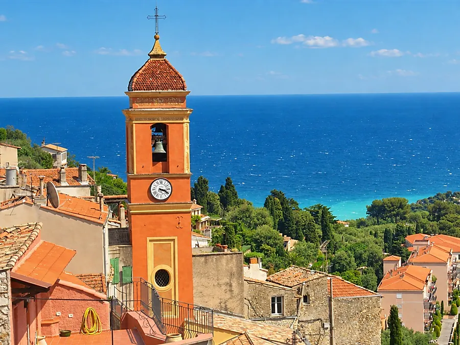 The bell tower of Roquebrune’s old village church above the rooftops, with the sea and Cap Martin beyond