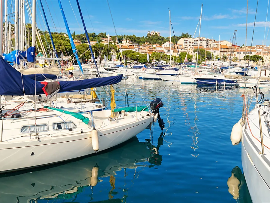 The harbor of Sainte-Maxime, its moored sailboats and the town on the hill
