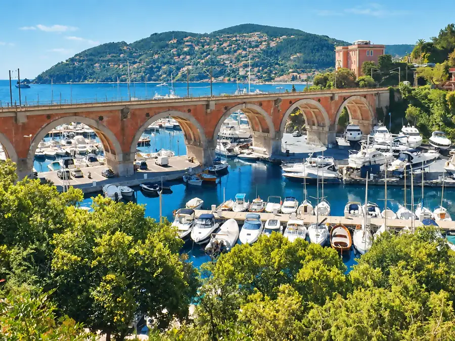 Un port de plaisance sous les arches d’un viaduc, face à la mer