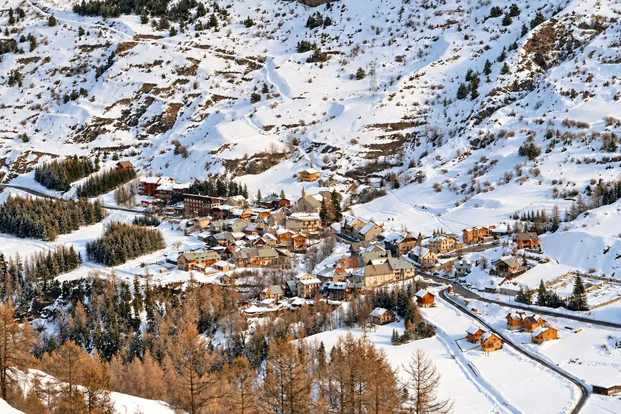 Le village de Vars sous la neige, ses chalets serrés autour de son église, au pied des pentes enneigées